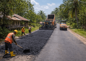 Pekerja melakukan pengaspalan jalan penghubung antar desa di Kutai Kartanegara