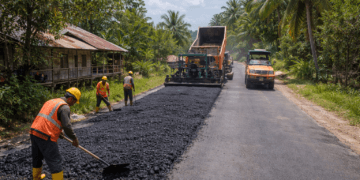 Pekerja melakukan pengaspalan jalan penghubung antar desa di Kutai Kartanegara