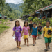 Anak-anak berjalan di jalan desa di pedalaman Mahakam Ulu.